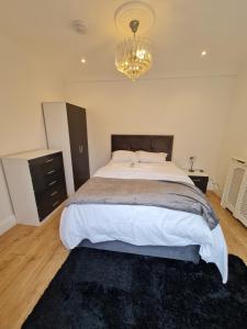 um quarto com uma cama grande e um lustre em JAh LODGE BRSITOL BIG HOUSE FREE PARKING 20 PERCENT OFF WEEKLY MONTHLY STAY BUSINESS CONTRACTOR STUDENTS RELOCATIONS 5BED em Bristol