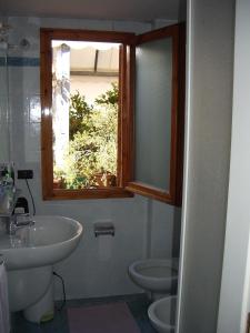 ein Bad mit einem Waschbecken, einem WC und einem Fenster in der Unterkunft Albergo Villa Sorriso in Fiesole
