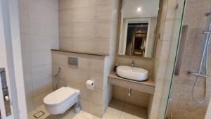 a bathroom with a toilet and a sink at Anggun Presidential Suites in Kuala Lumpur