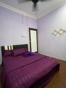 MerlimauにあるAR HOMESTAY & ROOMESTAYのベッドルーム(紫色のベッド1台、紫色の毛布付)
