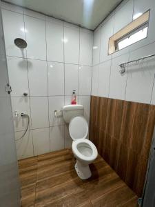 a bathroom with a white toilet and a shower at AR HOMESTAY & ROOMESTAY in Merlimau