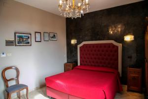 a bedroom with a red bed and a chandelier at Hotel Merlini in Florence