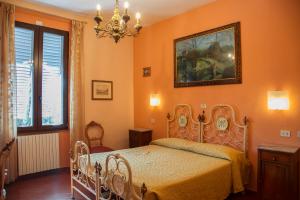 a bedroom with a bed and a painting on the wall at Hotel Merlini in Florence