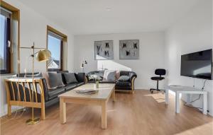 Stunning Home In Nordborg With Kitchen في نُوابورغ: غرفة معيشة مع أريكة وطاولة