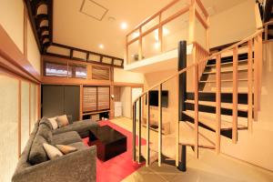a living room with a couch and a staircase at Fuji Onsenji Yumedono in Fujikawaguchiko