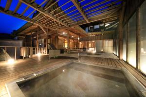 an indoor pool in a building with a wooden deck at Fuji Onsenji Yumedono in Fujikawaguchiko