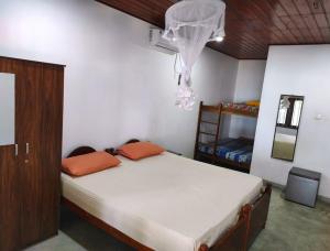 a bedroom with a bed and a chandelier at Blue Corals Beach Bungalow in Madihe East