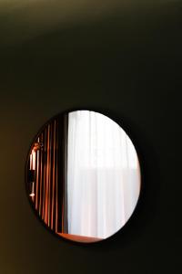LE SEOUL HOTEL في سول: مرآة مستديرة على جدار مع نافذة