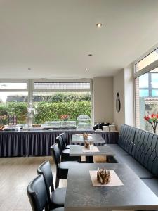 a restaurant with tables and chairs and a large window at Hotel Borchers in Dörpen