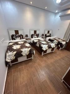 3 camas en una habitación con suelo de madera en شقة متكاملة غرفتين مع جاكوزي en Riad