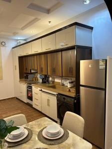a kitchen with a refrigerator and a table with chairs at شقة متكاملة غرفتين مع جاكوزي in Riyadh