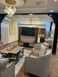 a living room with a table and chairs and a television at شقة متكاملة غرفتين مع جاكوزي in Riyadh