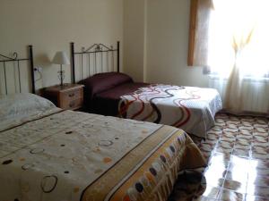a hotel room with two beds and a window at El molino de Foz Calanda in Foz-Calanda