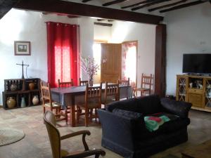 uma sala de estar com um sofá, uma mesa e cadeiras em El molino de Foz Calanda em Foz-Calanda