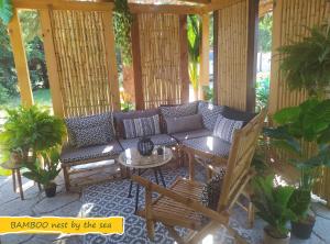 un patio con sofá, sillas y mesa en BAMBOO Nest by the sea en Epanomi