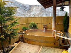 una vasca idromassaggio in un cortile con una montagna di Tsuyukusa a Takayama