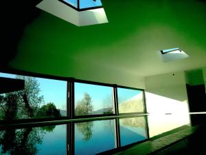 a room with large windows and a reflection in the water at ArsDurium Douro hotel in Cinfães