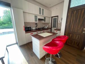 勒克瑙的住宿－Lush Green Workation Entire Home，厨房配有红色凳子和红色柜台