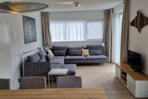 een woonkamer met een bank en een tv bij Vakantiewoning 1 aan zee, 400 meter van het strand in Zoutelande