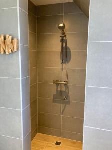 een badkamer met een douche en een glazen deur bij Vakantiewoning 1 aan zee, 400 meter van het strand in Zoutelande