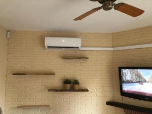 sala de estar con ventilador de techo y TV en Appartement la Cala de Mijas toegang tot strand, en Mijas