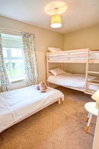 2 łóżka piętrowe w pokoju z oknem w obiekcie Branch cottage w mieście Limavady