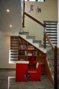 un escalier avec une table rouge et une étagère à livres dans l'établissement Vaishnavam Home stay, à Thekkady