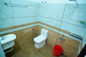 La salle de bains est pourvue de toilettes et d'un lavabo. dans l'établissement Vaishnavam Home stay, à Thekkady