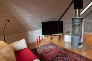 a living room with a fireplace and a flat screen tv at Villa Jupperi Espoossa in Espoo