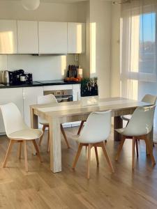 - une cuisine avec une table en bois et des chaises blanches dans l'établissement pourquoi notre T3 avec parking est pour vous ?, à Lille