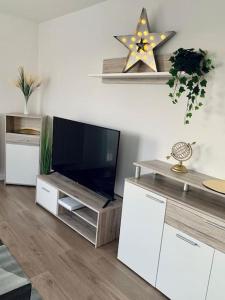 a living room with a television on a wooden entertainment center at pourquoi notre T3 avec parking est pour vous ? in Lille