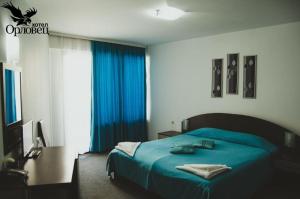 a bedroom with a blue bed with blue curtains at Hotel Orlovetz in Gabrovo