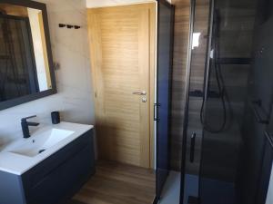 een badkamer met een wastafel en een douche met een glazen deur bij Guest house Damir in Ražanac +34 foto's