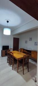 a dining room with a wooden table and chairs at Anchialos seafront appartement in Nea Anchialos