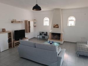 a living room with a couch and a tv at CAMARES HOUSE in Agioi Apostoli