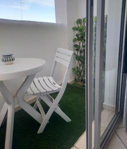 una silla blanca sentada junto a una mesa blanca en Entire Apartment, en Agadir