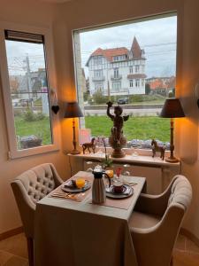 a dining room with a table and a window at B&B Villa Navy in Koksijde