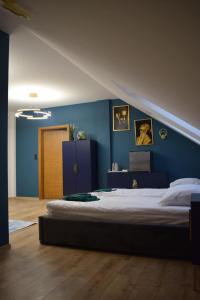 1 dormitorio con 1 cama grande y pared azul en Mały Książę, en Podzamcze