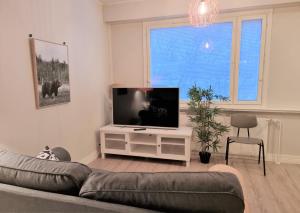 a living room with a couch and a flat screen tv at Studio Porin Otso, home away home in Pori city center in Pori