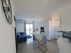 een keuken en een woonkamer met een tafel en stoelen bij Sea view penthouse in Żebbuġ