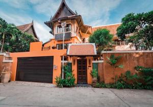 a large orange house with a garage at Villano Lilawadee Pool Villa in Na Jomtien