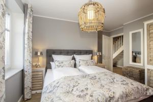 1 dormitorio con cama y lámpara de araña en Ferienwohnung Bootsmann en Langeoog