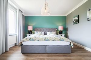 een slaapkamer met een groot bed met blauwe muren bij Ferienwohnung Hus up Höcht in Langeoog