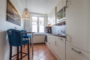 uma cozinha com uma mesa e uma cadeira azul em Ferienwohnung Hus up Höcht em Langeoog