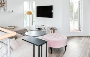 uma sala de estar com uma cadeira rosa e uma mesa em 5 Bedroom Beautiful Home In Karlstad em Karlstad