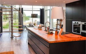 una cucina con armadi neri e ripiano in legno di 5 Bedroom Beautiful Home In Karlstad a Karlstad