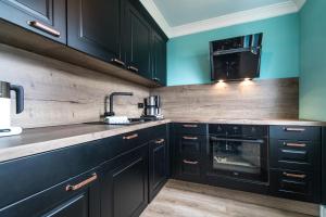 a kitchen with black cabinets and a stove top oven at Lieblingsinsel Langeoog in Langeoog