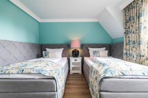 2 Einzelbetten in einem Zimmer mit blauen Wänden in der Unterkunft Lieblingsinsel Langeoog in Langeoog