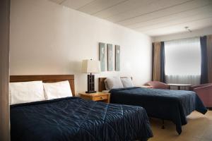 a hotel room with two beds and a window at Rockwell Resort in Niagara Falls