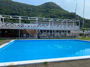 a large blue swimming pool in front of a building at BAYMARINAログハウス in Sakaide